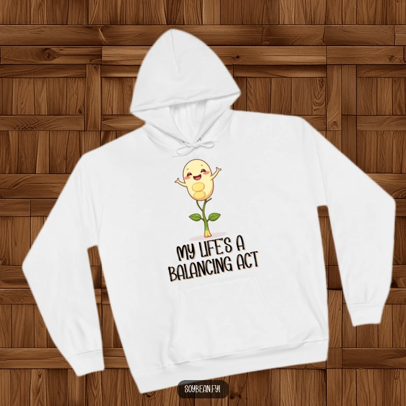 Funny hoodie showcasing a happy soybean character in a precarious but gleeful balance upon a delicate sprout, full of whimsical charm.