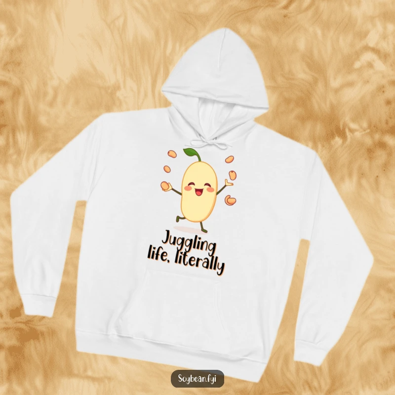 Funny hoodie featuring a jovial soybean character happily juggling its own beans, providing warmth and a dose of playful humor.