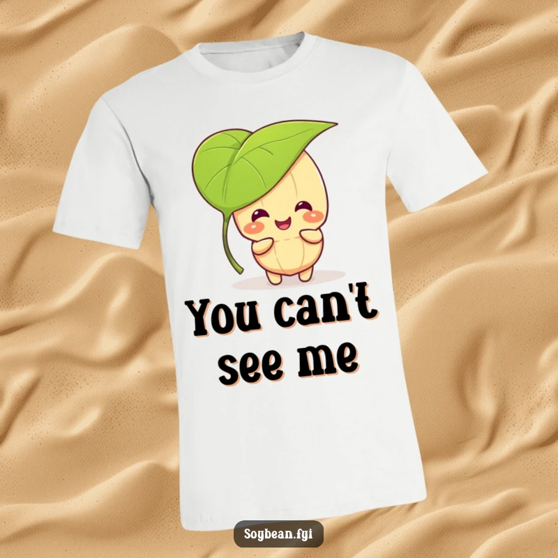 Funny kawaii soybean character giggling and playing peek-a-boo behind a large leaf, wearing a funny t-shirt.